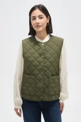 Chaleco acolchado color verde oliva, con diseño de rombos, cuello redondo y cierre frontal con botones metálicos. Cuenta con dos bolsillos frontales aplicados.