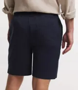 Bermuda masculina de sarga color azul marino, con cintura elástica, cordón ajustable y bolsillos traseros.
