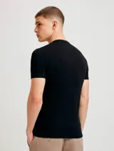 Camiseta de corte slim, color negro, con cuello redondo y mangas cortas.
