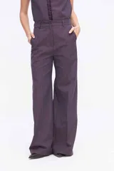 Pantalón de pierna amplia y tiro alto, confeccionado en tejido a rayas con una mezcla de algodón, poliéster y lino. Presenta un diseño de corte sastrero con bolsillos laterales y trabillas para cinturón.