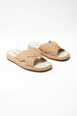 Sandalias bajas color beige con tiras cruzadas de yute y suela plana.