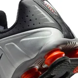 Championes Nike Shox R4 color negro, con diseño clásico de columnas amortiguadoras en el talón y capellada de material sintético con detalles perforados.