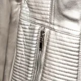 Campera plateada de símil cuero con cuello redondo, cierre frontal y bolsillos con cierre.
