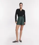 Short estilo clochard de material sintético (PU) color verde bosque, con cintura alta, pliegues frontales y cinturón a juego con hebilla metálica redonda.