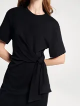 Vestido corto de manga corta con cuello redondo y detalle de lazo anudado en la cintura, confeccionado en tejido suave.