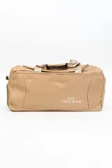 Bolso tipo duffel color beige con asas de mano y correa de hombro.