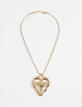 Collar dorado de acero quirúrgico hipoalergénico con cadena tipo serpiente y dije doble de corazón. El corazón exterior tiene un acabado irregular y el interior es liso y pulido.