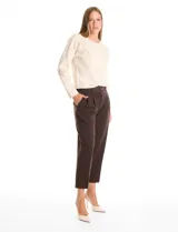 Pantalón de vestir color marrón con silueta fluida, diseño de pierna ancha y largo al tobillo. Cuenta con pretina con trabas para cinturón, cierre frontal con botón, pinzas en la parte delantera y bolsillos laterales funcionales.