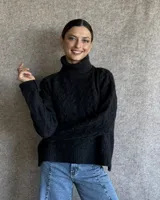 Sweater negro de lana con cuello alto y diseño trenzado.