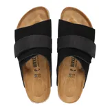 Sandalia Birkenstock modelo Kyoto, color negro, confeccionada en gamuza con una banda ancha ajustable mediante cierre de velcro. Presenta la clásica plantilla anatómica de corcho y látex con forro de gamuza y suela de EVA.