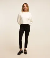 Pantalón tipo legging de tiro alto confeccionado en material sintético con recortes verticales y cierre lateral con cremallera.
