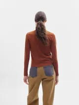 Remera de manga larga con cuello a la base, confeccionada en tejido acanalado con calce al cuerpo y diseño tipo crop.