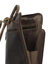Mochila de cuero marrón oscuro, elaborada de forma artesanal, con bolsillo frontal con relieve de diseño botánico de hojas. Cuenta con compartimento para notebook y cierre.