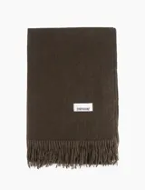 Pashmina lisa de color marrón con flecos en los extremos y etiqueta de la marca Symphorine.