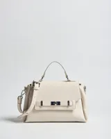 Cartera chica de símil cuero color crudo, con textura granulada, asa superior y correa bandolera regulable y desmontable. Cuenta con solapa frontal con detalle de tira decorativa y cierre giratorio metálico.
