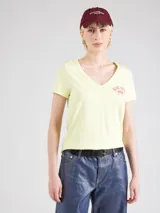 Remera color amarillo claro con escote en V y estampado frontal con la frase "NEW YORK GAP EST. 1969" en color rosado.