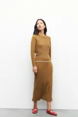 Sweater tramado color beige, de manga larga y cuello redondo.