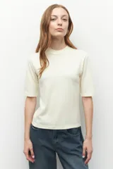 Remera de manga corta con cuello redondo, confeccionada en tejido de punto liso de color crema.