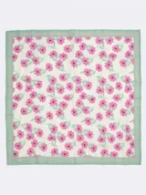 Pañuelo cuadrado de tejido satinado con estampado floral en tonos fucsia y verde sobre fondo crema, con borde perimetral en color verde.