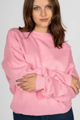 Sweater rosa de punto con cuello redondo y mangas largas.