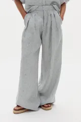 Pantalón de lino de corte ancho con diseño a rayas, tiro alto, bolsillos laterales y pinzas frontales.