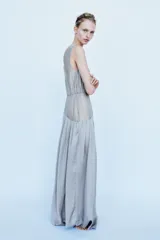 Vestido largo de tirantes con escote redondo, confeccionado en mezcla de viscosa. Presenta un diseño combinado con la parte superior en tejido ligero semitransparente y la parte inferior con volumen y drapeado asimétrico.