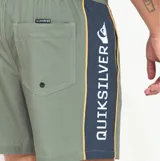 Short de baño Quiksilver de color verde militar, confeccionado en poliéster reciclado de secado rápido. Presenta cintura elástica con cordón ajustable contrastante, bolsillos laterales y una franja lateral con inscripción de la marca.