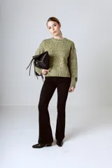 Sweater de tejido de punto con textura jaspeada en tonos verdes y amarillos, de corte holgado, cuello redondo y manga larga con detalle de etiqueta en el puño.