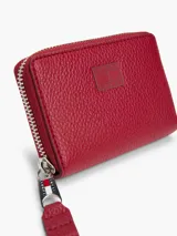 Billetera roja de poliuretano con cierre de cremallera y logo de Tommy Jeans en el frente.