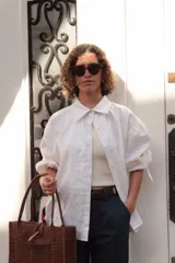 Camisa blanca de lino con cuello clásico, mangas abullonadas 3/4 y cierre frontal con botones.