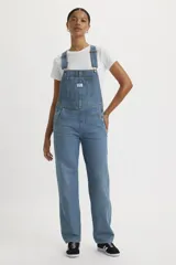 Jardinero de denim celeste con corte recto, bolsillos delanteros y traseros, y tirantes ajustables con hebillas metálicas.