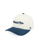 Gorra tipo trucker con corona estructurada en color crema y visera curva en color azul con textura aterciopelada. Presenta el logo de la marca bordado en el frente y detalle lateral.
