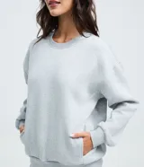 Buzo femenino de cuello redondo y manga larga, confeccionado en tejido de algodón con felpa. Presenta un diseño básico sin estampado, con puños y ruedo ajustados en tejido rib.