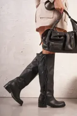 Botas de cuero color marrón con caña media, taco bajo y detalle de flecos.