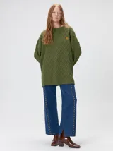 Sweater de cuello redondo con diseño de tejido en relieve de rombos, manga larga y calce holgado. Presenta logo bordado en el pecho y aberturas laterales en el ruedo.