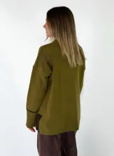 Sweater de punto azul marino con cuello en V, mangas largas con puños acanalados y detalle de línea en color marrón en el cuello y puños. Presenta un pequeño aplique decorativo en la parte inferior.