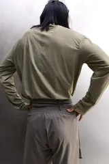 Camiseta de entrenamiento regular fit color gris oscuro, confeccionada en tejido técnico ligero y elástico con estructura. Cuenta con cuello redondo, manga larga y logo estampado en el bajo.