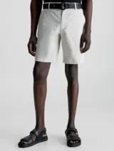 Shorts color crema de sarga de algodón orgánico con elasticidad añadida, talle medio, bragueta con cremallera, bolsillos laterales y traseros, cinturón con hebilla en forma de D incluido y micrologo de Calvin Klein.