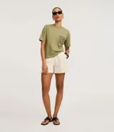 Remera de manga corta y cuello redondo color verde oliva, confeccionada en algodón, con un bolsillo cuadrado aplicado en el pecho con diseño de crochet intrincado.