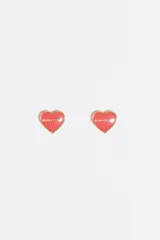 Pendientes pequeños en forma de corazón con acabado esmaltado en color rosa y borde metálico dorado. Incluyen el logo grabado en la superficie.