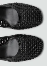Zapato destalonado de color negro con diseño trenzado, punta redondeada y tacón de bloque.
