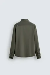 Camisa de corte regular fit color celeste, confeccionada en tejido fácil de planchar. Cuenta con cuello italiano abierto, manga larga con puño abotonado y cierre frontal con botonadura.