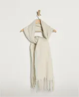 Bufanda manta de tejido suave color blanco hueso, con flecos definidos en los bordes y logo bordado en la parte inferior.