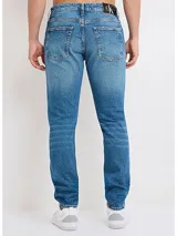 Pantalón de jean celeste con efecto desteñido, corte slim y diseño de cinco bolsillos.