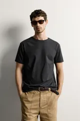 Remera regular fit de color verde oscuro, con cuello redondo y mangas cortas, de diseño liso y clásico.