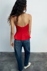 Top negro de escote redondo con tirantes finos y diseño peplum.