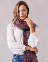 Bufandón rectangular de poliéster con estampado de arabescos en tonos rojos, azules y negros. Presenta terminaciones con flecos en los extremos.