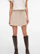 Pollera short de tiro alto y fit holgado, con diseño envolvente en la parte delantera y cierre lateral invisible.