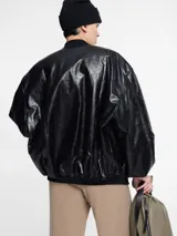 Chaqueta negra con cierre frontal, cuello redondo y mangas globo.