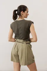 Short blanco de tiro alto, confeccionado en lino, con bolsillos laterales y cordón ajustable en la cintura.